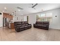An open-concept living room and kitchen with neutral tile floors and recessed lighting at 14180 W Willow Ave, Surprise, AZ 85379