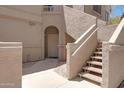 Close-up of the front entrance with an arched doorway and staircase leading to upper levels at 15050 N Thompson Peak Pkwy # 1001, Scottsdale, AZ 85260