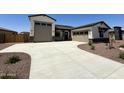 Home featuring a two-car and single-car garage, a concrete driveway, and neutral exterior color schemes with stone accents at 17324 W Royal Palm Rd, Waddell, AZ 85355