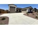 Spacious home featuring a two-car and single-car garage, a driveway, and neutral exterior color schemes with stone accents at 17324 W Royal Palm Rd, Waddell, AZ 85355