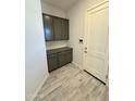 Mud room with gray cabinets, a countertop, an electrical outlet, an electronic keypad and a white door at 17324 W Royal Palm Rd, Waddell, AZ 85355