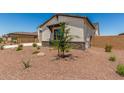 A nicely landscaped side yard featuring desert landscaping and a charming neutral-colored home at 17324 W Royal Palm Rd, Waddell, AZ 85355