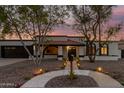 Inviting home exterior with well-lit walkway, desert landscaping, and unique architectural details under a stunning twilight sky at 1736 N Ashbrook Cir, Mesa, AZ 85213