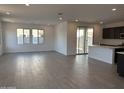 Open-concept living room with tile floors and access to the kitchen and backyard at 17989 W Lupine Ave, Goodyear, AZ 85338