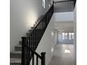 Bright foyer features a staircase with black railing and carpeted steps at 18061 W Lupine Ave, Goodyear, AZ 85338