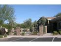 Community pool with lounge chairs surrounded by a secure iron fence and lush landscaping at 18250 N Cave Creek Rd # 123, Phoenix, AZ 85032