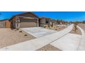 Street view of single-story homes with low maintenance yards, concrete driveway, and neutral tones at 18374 W Poston Dr, Surprise, AZ 85387