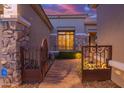 Inviting home featuring a gated courtyard, stone accents, and a beautifully lit front entry at 22847 N 53Rd E St, Phoenix, AZ 85054