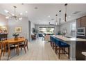 Open-concept kitchen and living area featuring sleek countertops, a modern chandelier, and ample natural light at 24226 N 22Nd St, Phoenix, AZ 85024