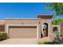 Beige home featuring an arched entrance and two car garage at 25230 S Berry Brook Dr, Sun Lakes, AZ 85248