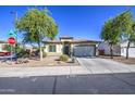 Lovely single-story home with low-maintenance desert landscaping and mature trees under a clear blue sky at 25659 W Forest Grove Ave, Buckeye, AZ 85326