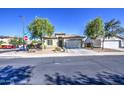 Inviting single-story home with desert landscaping, mature trees, and a well-maintained front yard at 25659 W Forest Grove Ave, Buckeye, AZ 85326