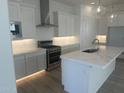 Modern kitchen boasts white cabinets, stainless steel appliances, and a large island with a sink at 3637 E Rochelle Cir, Mesa, AZ 85213