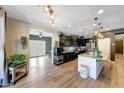Open kitchen with an island and granite countertops, dark wood cabinets, and a view into an adjacent room at 41143 W Rio Bravo Dr, Maricopa, AZ 85138
