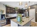 Stylish kitchen featuring dark wood cabinets, granite countertops, and pendant lights over the island at 41143 W Rio Bravo Dr, Maricopa, AZ 85138