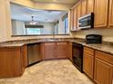 Well-equipped kitchen featuring stainless steel appliances, wood cabinetry, and breakfast bar at 4117 W Allen St, Laveen, AZ 85339