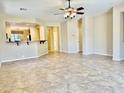Bright, open-concept living room with tile flooring, a ceiling fan, and an adjoining kitchen area at 4117 W Allen St, Laveen, AZ 85339