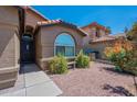 Close-up of a home showcasing an arched window, front door, and desert landscaping at 5952 E Phelps Rd, Scottsdale, AZ 85254