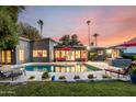 Backyard featuring a sparkling swimming pool, ample seating, and lush landscaping, perfect for relaxation and entertaining at 6746 E Monterosa St, Scottsdale, AZ 85251