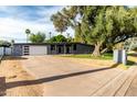 This contemporary home boasts a sleek facade, a spacious driveway, and mature trees for added curb appeal at 6746 E Monterosa St, Scottsdale, AZ 85251