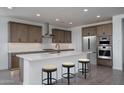 Modern kitchen features a large island, stainless steel appliances, and sleek cabinetry at 7944 W Griswold Rd, Peoria, AZ 85345