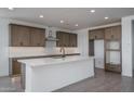 Modern kitchen with sleek white countertops, brown cabinets and stainless steel appliances at 7944 W Griswold Rd, Peoria, AZ 85345