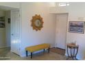Bright entryway with a sunburst mirror, yellow bench, and neutral decor that creates a welcoming atmosphere at 8700 E Mountain View Rd # 2029, Scottsdale, AZ 85258