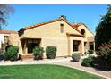 Charming single-story home with stucco exterior, tile roof, well maintained lawn and mature bushes at 9115 N 101St Way, Scottsdale, AZ 85258