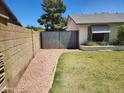Gated side yard with a rock path and a well-kept lawn, providing a private outdoor space at 949 N Ricardo N Cir, Mesa, AZ 85205