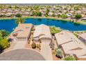 Scenic aerial view of homes on a lake featuring mature trees and desert landscaping at 10526 W Tonopah Dr, Peoria, AZ 85382