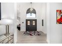Bright entryway showcases a decorative front door with tiled flooring and an arched window above at 10662 E Carol Ave, Scottsdale, AZ 85258