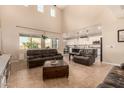 Spacious living room featuring high ceilings, large windows, and tile flooring that seamlessly flows into the open-concept design at 10718 E Vivid Ave, Mesa, AZ 85212