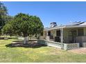 Beautiful backyard with mature trees, green lawn, and covered patio area for relaxation at 10721 W Mission Ln, Sun City, AZ 85351