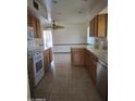 Bright kitchen features tile floors, wood cabinets, and stainless steel appliances at 10721 W Mission Ln, Sun City, AZ 85351