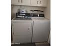 Functional laundry room with a dryer and a washing machine, providing convenience for everyday chores at 10721 W Mission Ln, Sun City, AZ 85351