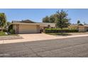 Charming single-story home with a well-manicured front yard and attached two-car garage, showcasing a bright and sunny day at 12927 W Shadow Hills Dr, Sun City West, AZ 85375