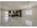 View of the living space flowing into the open kitchen with dark cabinets and stainless steel appliances at 13430 S Garnet Rd, Buckeye, AZ 85326