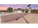 Suburban home with a long driveway, desert landscaping, a two-car garage, and a neutral color scheme at 15825 N 45Th St, Phoenix, AZ 85032