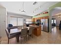 Eat-in kitchen featuring stainless steel appliances, wood cabinetry, a breakfast bar, and a view of living area at 16661 W Central St, Surprise, AZ 85388