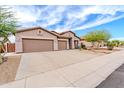 Stunning view of the home featuring a large three-car garage and beautiful desert landscaping at 18633 W Mcneil St, Goodyear, AZ 85338
