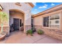 Inviting home entrance, adorned with elegant stone accents and beautiful potted plants at 2103 E Canyon Pl, Chandler, AZ 85249