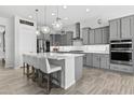 Contemporary kitchen featuring an island with bar seating, modern pendant lights, and plenty of cabinet space at 23097 N 95Th Dr, Peoria, AZ 85383