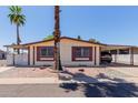 Well-maintained single-story home featuring a carport and neat landscaping with a central palm tree at 245 S 56Th St # 135, Mesa, AZ 85206
