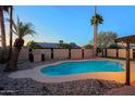 Sparkling pool area with surrounding rock accents, block wall, and tropical palm trees creating a private oasis at 3054 W Redfield Rd, Phoenix, AZ 85053