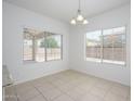 Bright dining area features neutral tile flooring, a modern light fixture, and natural light through two large windows at 3361 E Wisteria Pl, Chandler, AZ 85286
