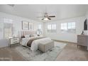 Airy main bedroom with carpet, a ceiling fan, and an abundance of natural light from multiple windows at 3361 E Wisteria Pl, Chandler, AZ 85286