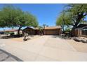 Single-story home with mature trees, desert landscaping, and a two-car garage at 4516 E Willow Ave, Phoenix, AZ 85032