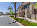 View of the townhome's exterior highlighting its stucco finish, balconies, and landscaping at 4711 S Vapor --, Mesa, AZ 85212