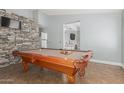 Spacious game room featuring a billiard table and a stone accent wall at 4741 N 85Th Ave, Phoenix, AZ 85037