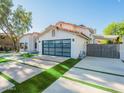 Contemporary home with a modern garage door, clean landscaping, and a stylish, geometric driveway at 4748 E Redfield Rd, Phoenix, AZ 85032